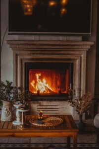 About A cozy and elegant interior design featuring a luxurious living room with a lit fireplace.